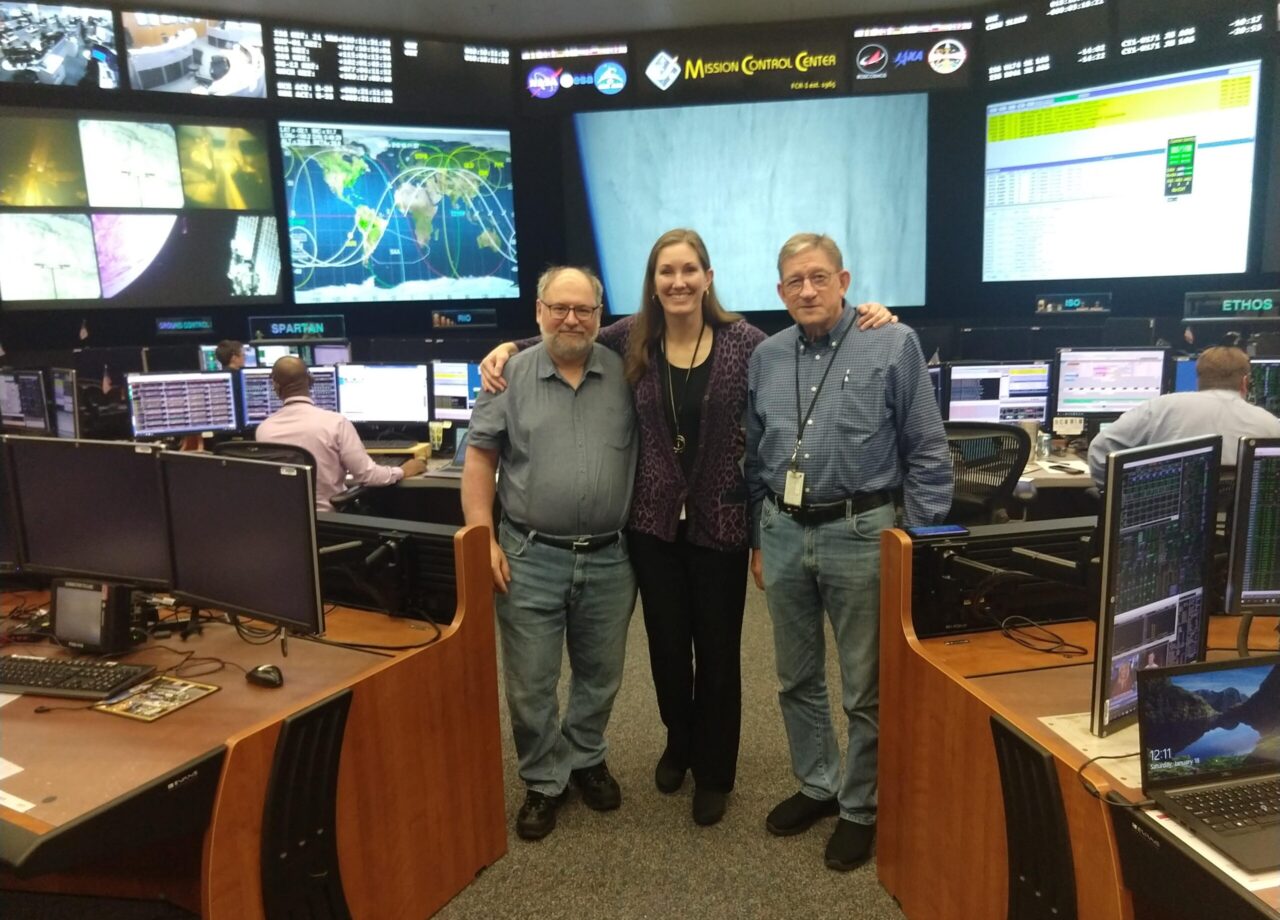 Project manager Jennifer Inman, aircraft mission coordinator Harry Verstynen, and technical lead Rich Schwartz pose in mission control center.
