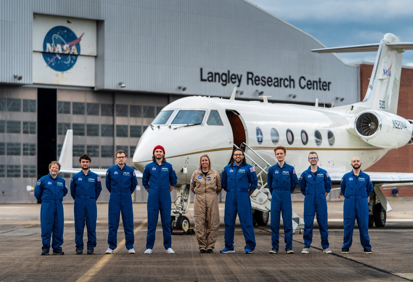 The KiNET-X crew stands in front of an aircraft at the Langle Research Center hangar.