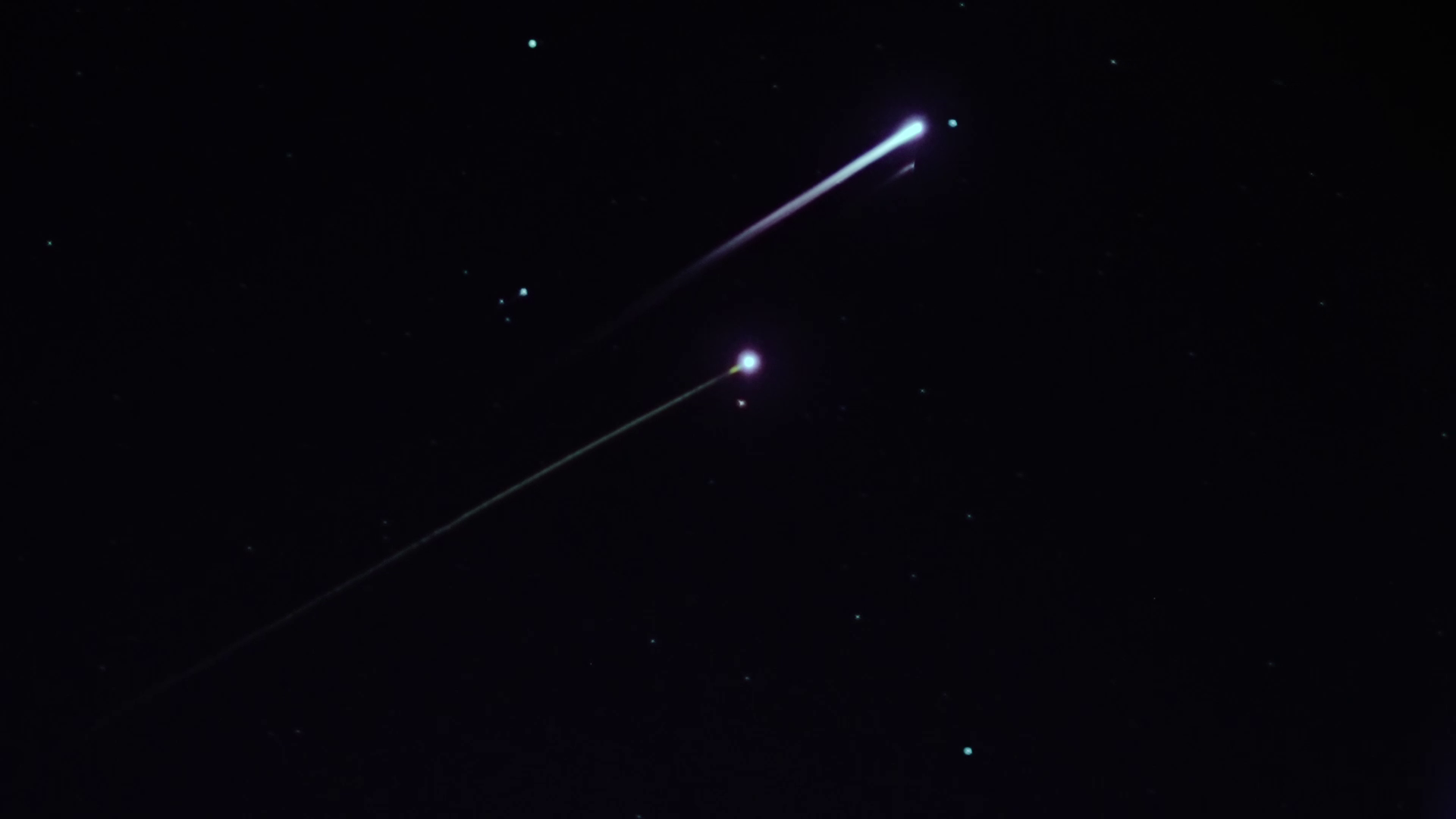 Two streaks of light appear in the night sky as LOFTID reenters Earth's atmosphere.