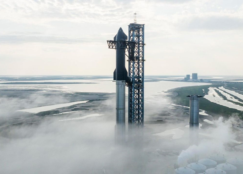 SpaceX's Starship and super heavy rocket on a launchpad surrounded by low fog.